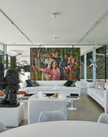 Interior living space with bronze figure on coffee table, framed portrait sketch on wall, on cover of 'Homes for Collectors', by Lannoo Publishers.