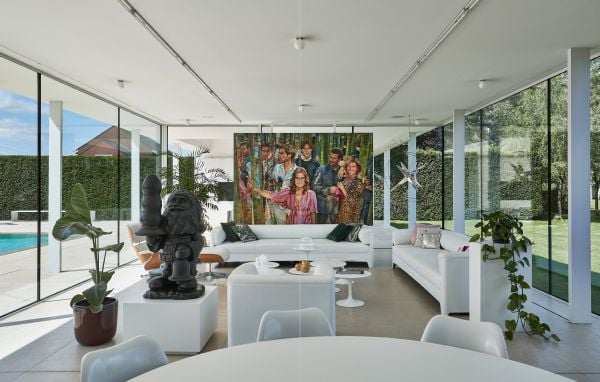Book cover of Homes for Collectors, featuring a interior living space with bronze figure on coffee table, with a framed portrait sketch on wall. Published by Lannoo Publishers.