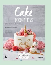 Single tiered cake covered in white fondant, with 'Party' in gold writing, gold unicorn horn on top, on cover of 'Cake Decorations', by Lannoo Publishers.
