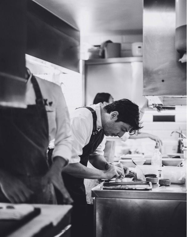 Book cover of Oak. Marcelo, featuring Michelin star Chef Marcelo Ballardin leaning forward with right hand on back of neck. Published by Lannoo Publishers.