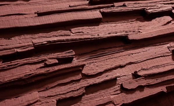 Book cover of Paperworld, featuring black cubes of recycled cardboard resembling small charcoal briquettes. Published by Lannoo Publishers.