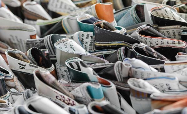 Book cover of Paperworld, featuring black cubes of recycled cardboard resembling small charcoal briquettes. Published by Lannoo Publishers.