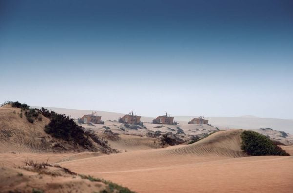 Book cover of Desert Escapes, with sun-loungers looking across a desert landscape, under a canvas canopy. Published by Lannoo Publishers.