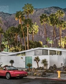 Book cover of Carchitecture USA: American Houses With Horsepower, with a blue Cadillac parked outside the front of a pink, flat-roofed house, with palm trees and the sea behind. Published by Lannoo Publishers.