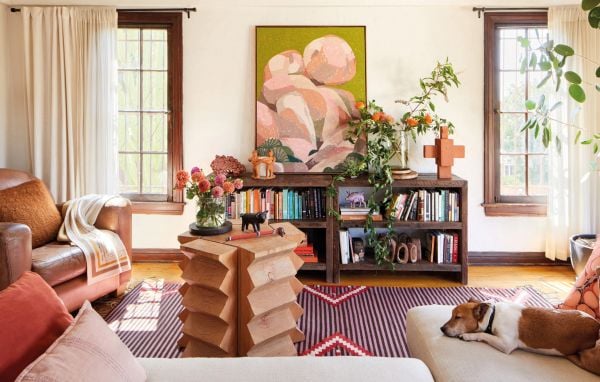 Book cover of Los Angeles Interiors, with an interior living room with a bulbous terracotta armchair, large pot plant in corner, arched doors looking out into garden. Published by Lannoo Publishers.