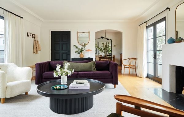 Book cover of Los Angeles Interiors, with an interior living room with a bulbous terracotta armchair, large pot plant in corner, arched doors looking out into garden. Published by Lannoo Publishers.