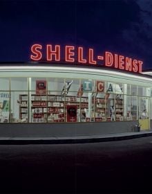 Book cover of Gas Stations, An Illustrated History, with a petrol assistant in blue overalls filling up white car, with woman leaning on side of bonnet. Published by Lannoo Publishers.