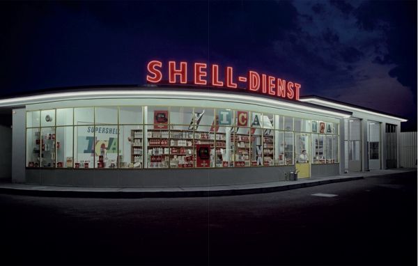 Book cover of Gas Stations, An Illustrated History, with a petrol assistant in blue overalls filling up white car, with woman leaning on side of bonnet. Published by Lannoo Publishers.