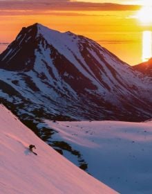 Snowboarder on snowy peak, biker riding over rough terrain, on cover of 'Mountains, Sporting in the most beautiful mountain regions in Europe', by Lannoo Publishers.