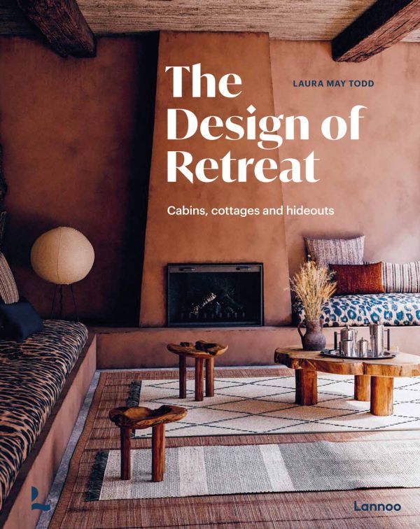 Book cover of The Design of Retreat, Cabins, Cottages and Hideouts, with a warm terracotta interior living space with animal print seating, wood tables, and fireplace. Published by Lannoo Publishers.