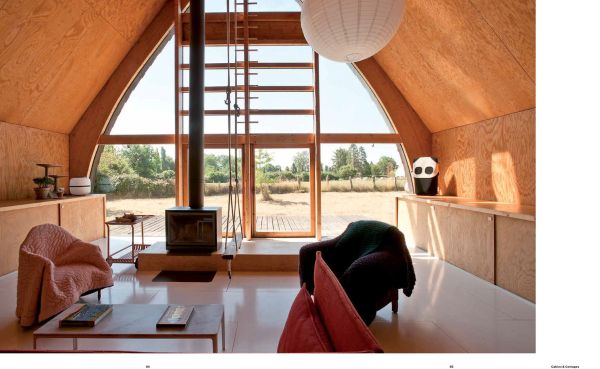 Book cover of The Design of Retreat, Cabins, Cottages and Hideouts, with a warm terracotta interior living space with animal print seating, wood tables, and fireplace. Published by Lannoo Publishers.