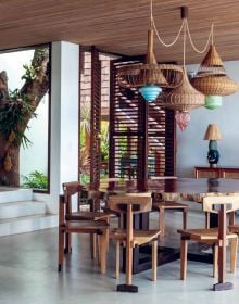 Warm terracotta interior living space with animal print seating, wood tables, fireplace, on cover of 'The Design of Retreat, Cabins, Cottages and Hideouts', by Lannoo Publishers.