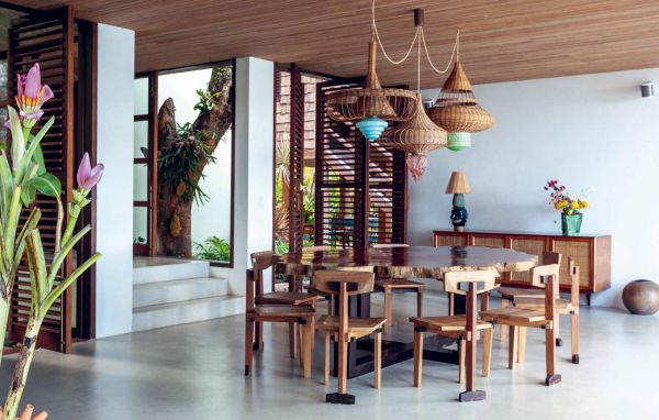 Book cover of The Design of Retreat, Cabins, Cottages and Hideouts, with a warm terracotta interior living space with animal print seating, wood tables, and fireplace. Published by Lannoo Publishers.