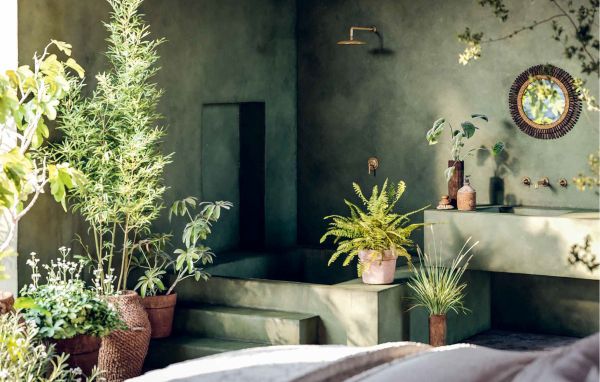 Book cover of The Design of Retreat, Cabins, Cottages and Hideouts, with a warm terracotta interior living space with animal print seating, wood tables, and fireplace. Published by Lannoo Publishers.