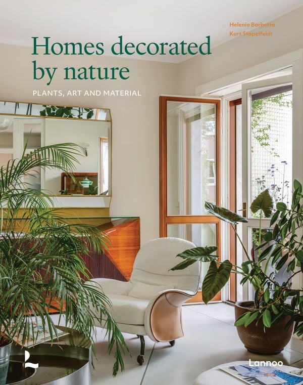 Book cover of Homes Decorated by Nature, with an interior living room with soft cream leather chair, large mirror and houseplants. Published by Lannoo Publishers.