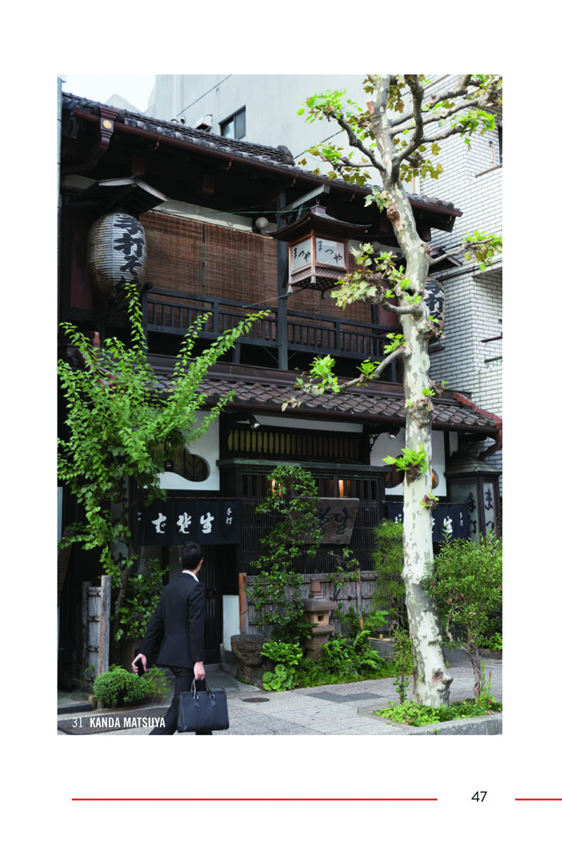 Walkway under building roof ledge, line of bamboo trees to left, The 500 Hidden Secrets of Tokyo in black font on white banner