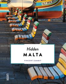 Row of multicolored slated wood chairs, near harbour edge, with boat, on cover of Hidden Malta', by Luster Publishing.