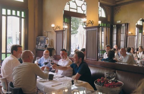 Plate of fried food with kale and lemon slice, glass of beer on walnut table, on cover of 'Belgium for Foodies', by Luster Publishing.