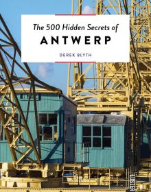 Large yellow steel structure towering over green wooden outhouses, on cover of 'The 500 Hidden Secrets of Antwerp', by Luster Publishing.