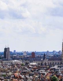 Large yellow steel structure towering over green wooden outhouses, on cover of 'The 500 Hidden Secrets of Antwerp', by Luster Publishing.