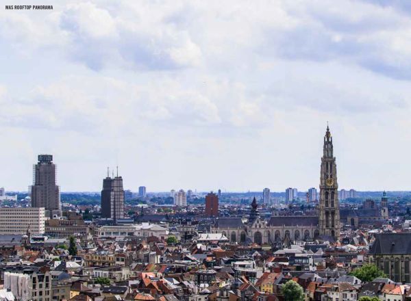 Large yellow steel structure towering over green wooden outhouses, on cover of 'The 500 Hidden Secrets of Antwerp', by Luster Publishing.