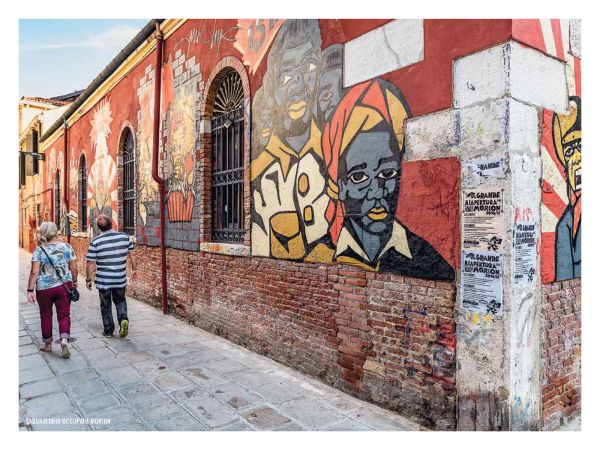 Book cover of The 500 Hidden Secrets of Venice, with a gondola workshop on canal edge. Published by Luster Publishing.