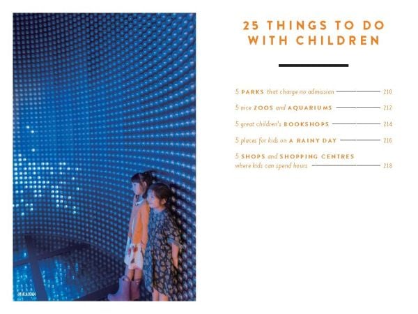 Book cover of The 500 Hidden Secrets of Tokyo, with a couple in boat on Imperial Palace moat, rowing beneath pink blossom trees. Published by Luster Publishing.