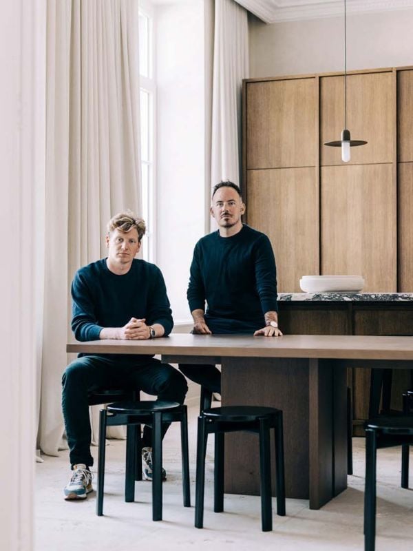 Linen book cover of Morph?, Van Damme - Vandeputte Architects, with an Interior space with low black coffee-table, white bust sculpture on plinth, wood chair, and white marble fireplace. Published by Luster Publishing.