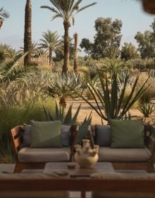 Book cover of Rock the Kasbah: A Journey Through Morocco’s Most Soulful Stays; featuring a homely interior space with a rug and basket lighting fixture. Published by Luster Publishing.