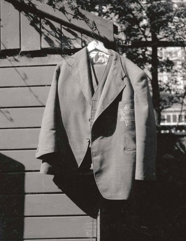 Book cover of The Persecution of the Jews in Photographs, The Netherlands 1940-1945', featuring a Jewish couple walking through a square in Amsterdam. Published by WBooks.