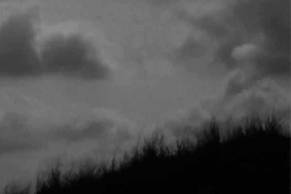 Book cover of Dirck Nab – Paysage Dessiné, with the artist sitting amongst coastal dunes. Published by Waanders Publishers.