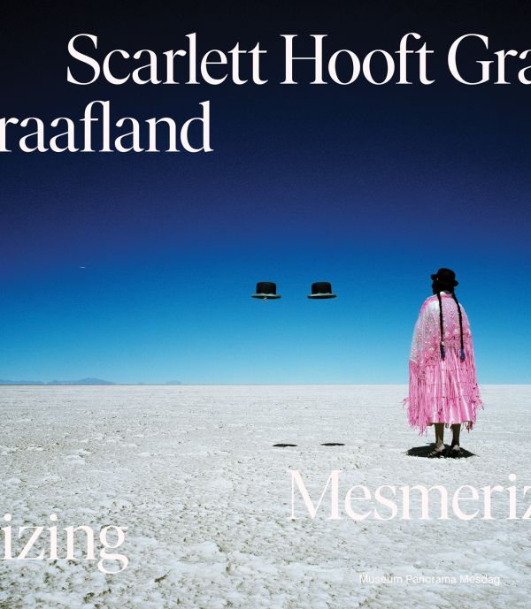 Book cover of Scarlett Hooft Graafland: Mesmerizing; featuring a figure standing in the desert, with two floating hats. Published by Waanders Publishers.