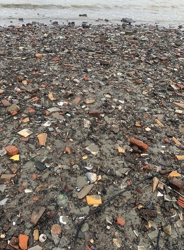 Book cover of Jutten, with a beach area covered in stones, rocks and bricks. Published by Hopper&Fuchs.