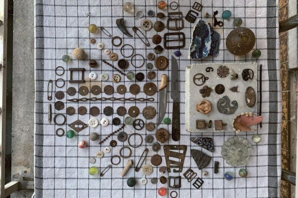 Book cover of Jutten, with a beach area covered in stones, rocks and bricks. Published by Hopper&Fuchs.