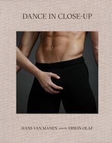Torso of white male in black pants, white female hand on crotch area, on beige linen cover of 'Dance in Close-Up, Hans van Manen seen by Erwin Olaf', by Hannibal Books.