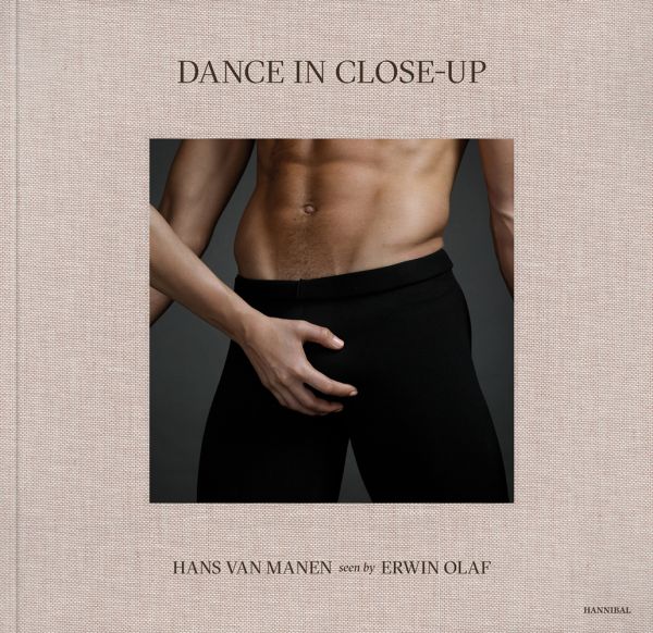 Linen book cover of Dance in Close-Up, Hans van Manen seen by Erwin Olaf, featuring the torso of male in black pants, with another person's hand on crotch area. Published by Hannibal Books.