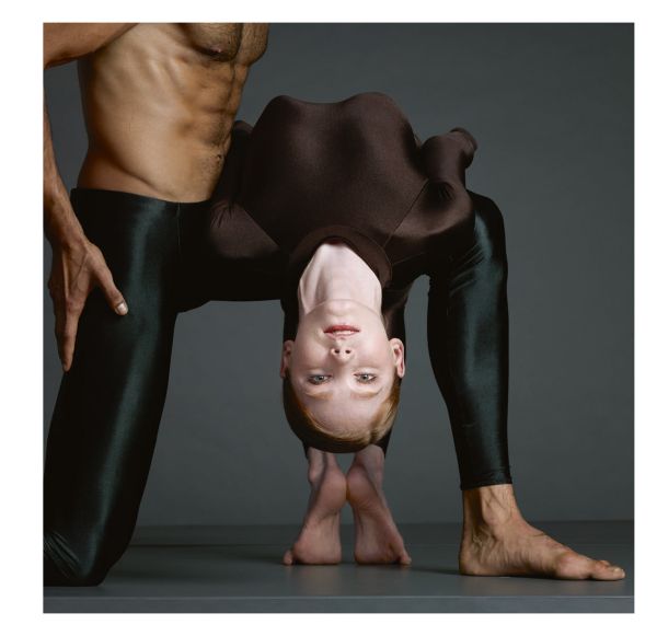 Linen book cover of Dance in Close-Up, Hans van Manen seen by Erwin Olaf, featuring the torso of male in black pants, with another person's hand on crotch area. Published by Hannibal Books.