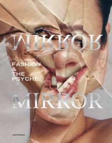 Book cover of Mirror Mirror, Fashion & the Psyche, with a portrait of female on magazine page with folds skewing face. Published by Hannibal Books.