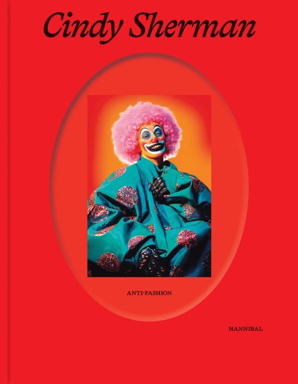 Book cover of Cindy Sherman: Anti-Fashion, with the artist dressed as a clown, wearing a pink curly wig. Published by Hannibal Books.