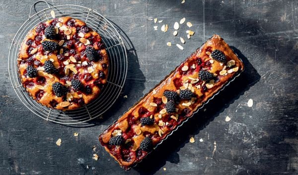 Book cover of The Home Baking Book: Timeless Recipes for Artisanal Treats, with a table of bread, pastries, cakes and tarts. Published by Hannibal Publishers.