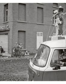 Book cover of Sidelines: John Vink, featuring a black dog and workers picking plants from water. Published by Hannibal Books.