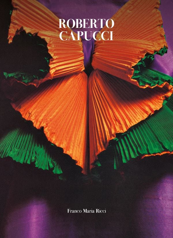 Book cover of Robert Capucci, with a shiny, pleated material in orange and green. Published by Franco Maria Ricci editore.