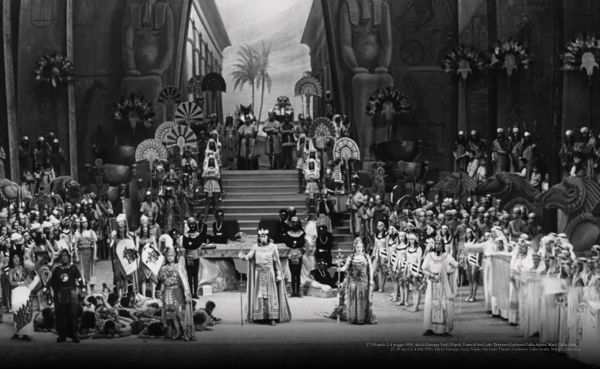 Book cover of Giampoalo Guida's Callas 100, with Maria Callas smiling as she looks out of the rear windscreen of a car, surrounded by fans. Published by Scripta Maneant Editori.